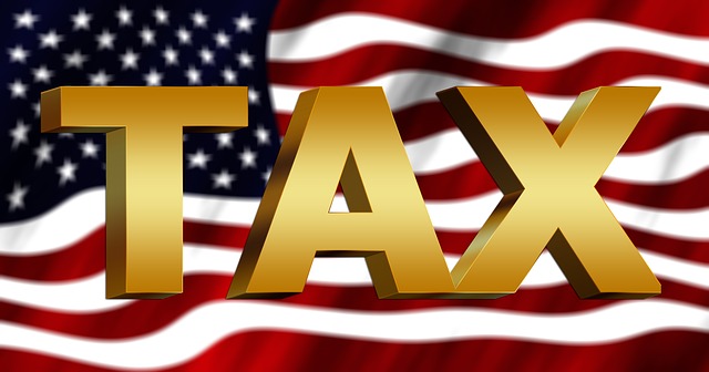 המילה מיסים באנגלית TAX, וברקע דגל
