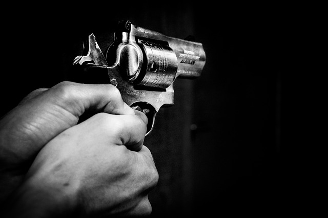 תמונה שחור לבן של אדם המחזיק אקדח